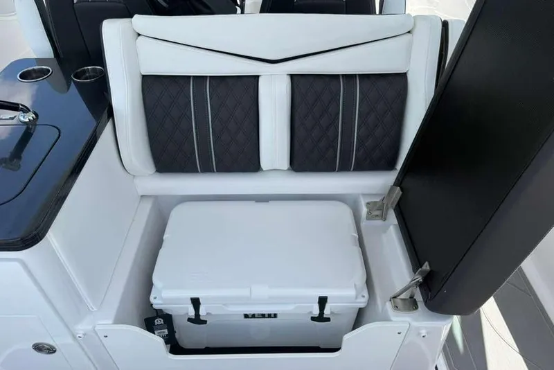 Slide: The Image of 2026 Monterey Elite 30 OB boat interior with cushioned seating and built-in cooler storage. - 63