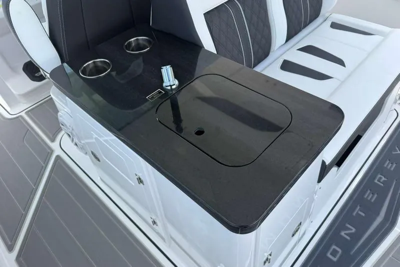 Slide: The Image of Luxury seating area on 2026 Monterey Elite 30 OB boat with cup holders and sleek design. - 66