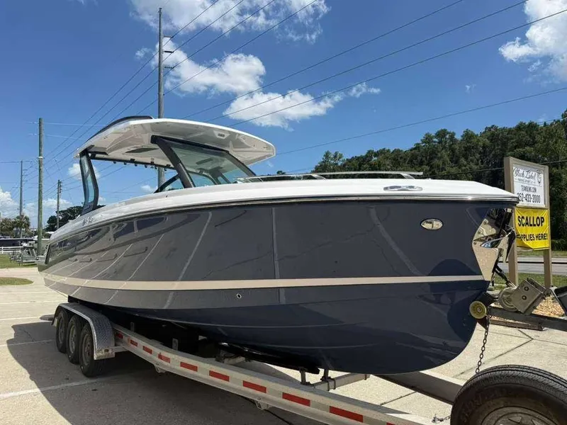 Slide: The Image of A 2026 Monterey Elite 30 OB boat on a trailer under a blue sky. - 1