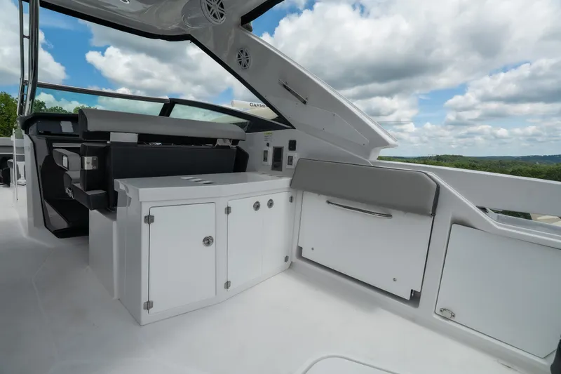 Slide: The Image of 2026 Monterey 385SS Super Sport boat interior with sleek cabinetry and seating under a blue sky. - 10