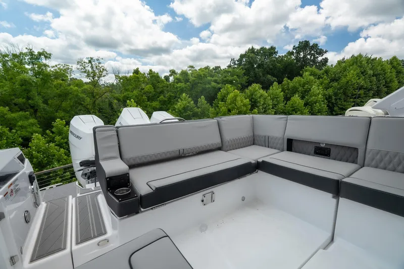 Slide: The Image of 2026 Monterey 385SS Super Sport boat with luxurious seating and scenic forest backdrop. - 13