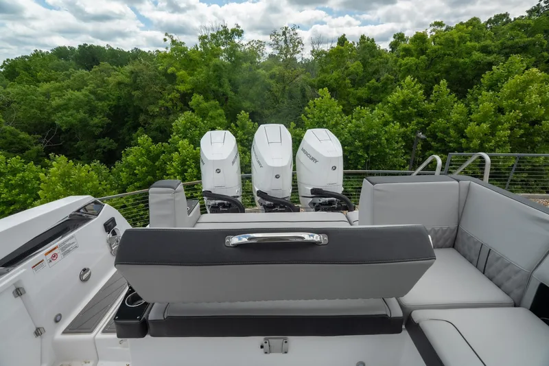 Slide: The Image of 2026 Monterey 385SS Super Sport boat with triple Mercury engines, luxurious seating, and lush green backdrop. - 16