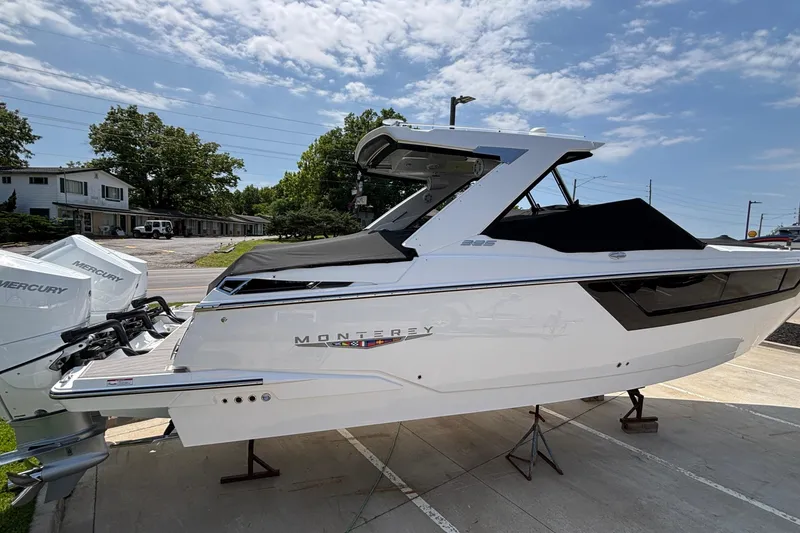 Slide: The Image of 2026 Monterey 385SS Super Sport boat with Mercury engines, parked outdoors under a blue sky. - 5