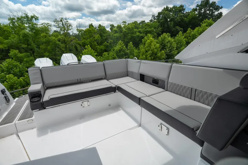 Slide: The Image of Luxurious seating area on the 2026 Monterey 385SS Super Sport boat, surrounded by lush greenery. - 9