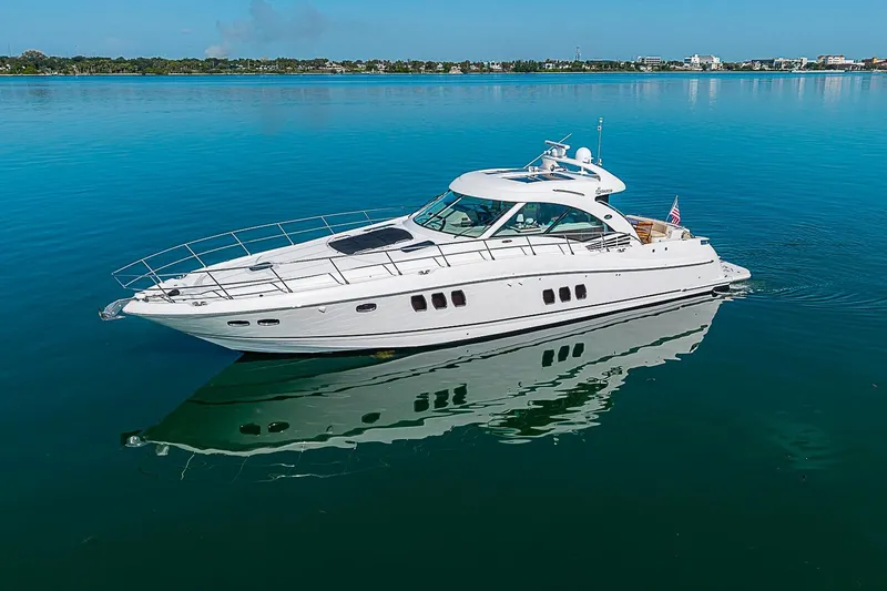 Slide: The Image of 2008 Sea Ray 60 Sundancer yacht on calm blue water, reflecting the clear sky. - 7