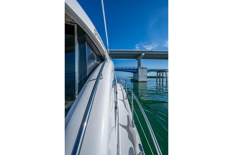 Slide: The Image of 2008 Sea Ray 60 Sundancer yacht cruising under a bridge on a sunny day. - 58