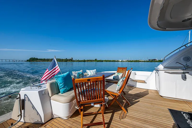 Slide: The Image of 2008 Sea Ray 60 Sundancer yacht deck with seating, American flag, and ocean view. - 62