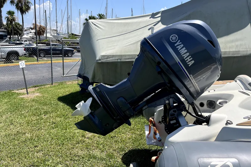 Slide: The Image of Yamaha outboard motor on a boat, parked near a marina with covered vessels. - 77