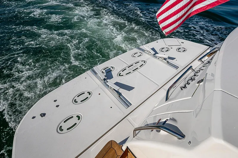 Slide: The Image of 2008 Sea Ray 60 Sundancer yacht stern with American flag, cruising on open water. - 67