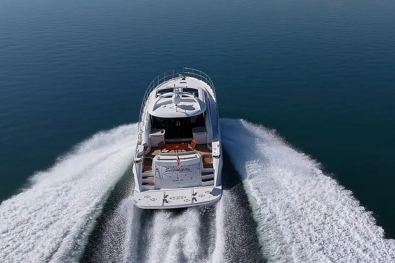 Slide: The Image of 2008 Sea Ray 60 Sundancer yacht cruising on open water, aerial rear view. - 11