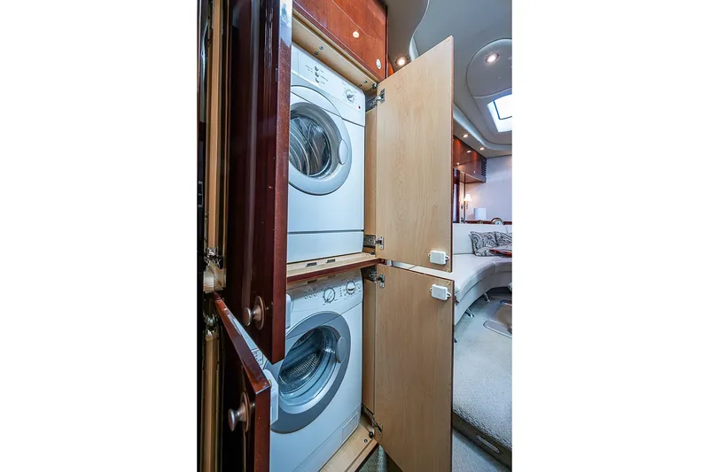Slide: The Image of Laundry area inside 2008 Sea Ray 60 Sundancer yacht, featuring stacked washer and dryer. - 54