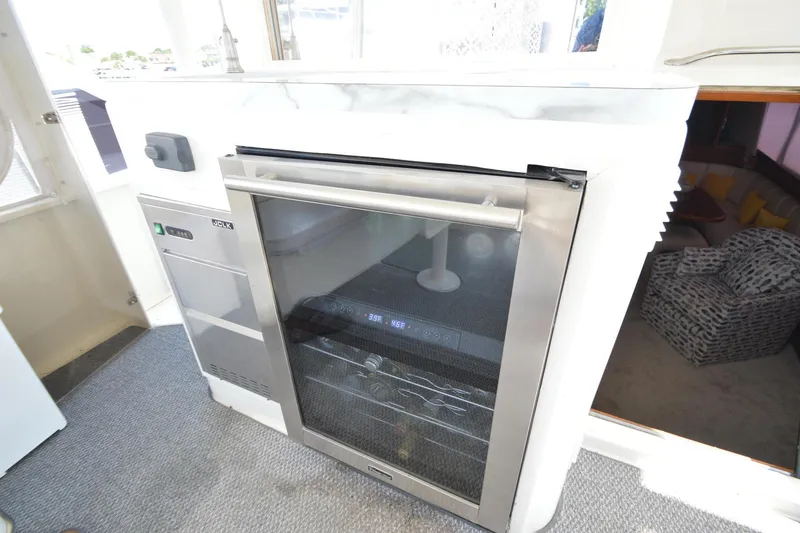 Slide: The Image of 1995 Ocean 48 Cockpit Motor Yacht interior with modern refrigerator and carpeted flooring. - 57