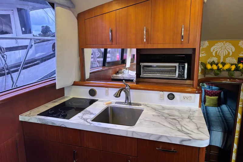 Slide: The Image of 1995 Ocean 48 Cockpit Motor Yacht kitchen with marble countertop and modern appliances. - 12