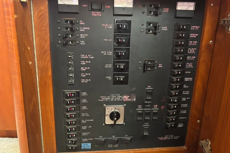 Slide: The Image of Electrical panel of a 1995 Ocean 48 Cockpit Motor Yacht with labeled switches and controls. - 35