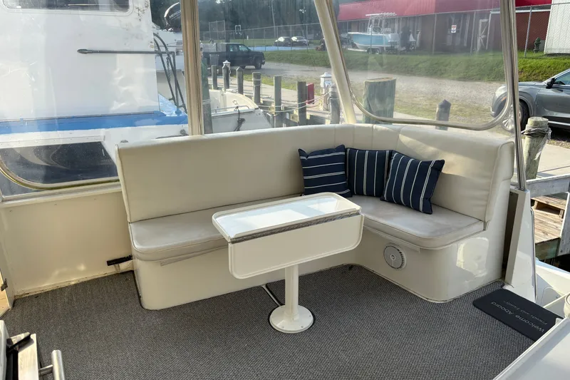 Slide: The Image of 1995 Ocean 48 Cockpit Motor Yacht interior with cushioned seating and striped pillows. - 37