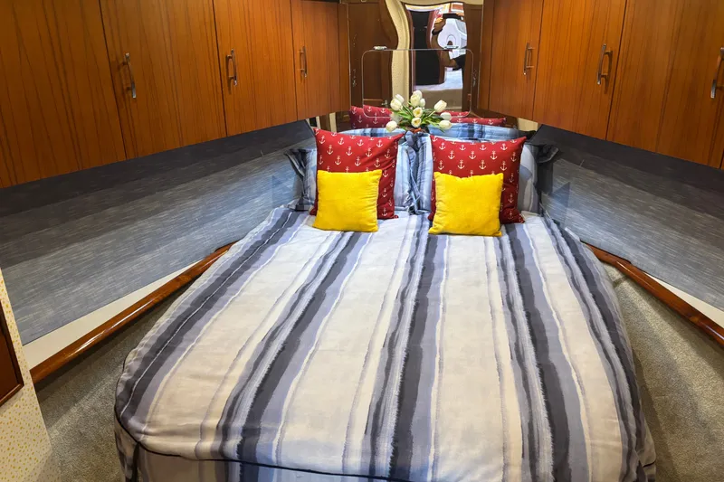 Slide: The Image of Cozy bedroom in 1995 Ocean 48 Cockpit Motor Yacht with striped bedding and colorful pillows. - 27