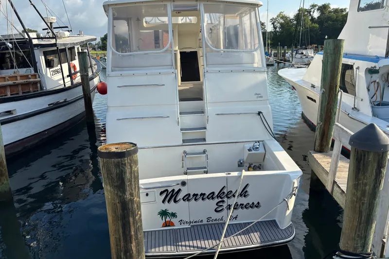 Slide: The Image of 1995 Ocean 48 Cockpit Motor Yacht docked, rear view with "Marrakech Express" name. - 45