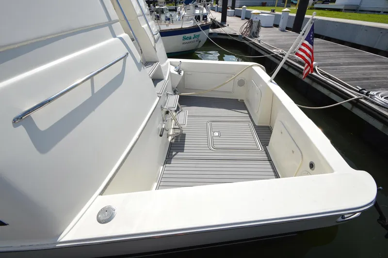 Slide: The Image of 1995 Ocean 48 Cockpit Motor Yacht docked, featuring spacious deck and American flag. - 60