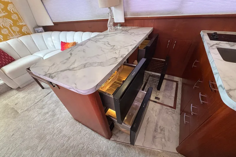 Slide: The Image of Luxurious 1995 Ocean 48 Cockpit Motor Yacht interior with marble countertops and elegant seating. - 14
