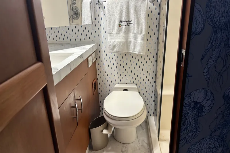 Slide: The Image of Bathroom interior of 1995 Ocean 48 Cockpit Motor Yacht with modern fixtures and patterned wallpaper. - 25