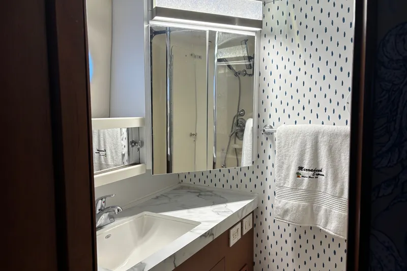 Slide: The Image of Bathroom interior of 1995 Ocean 48 Cockpit Motor Yacht with marble countertop and patterned wallpaper. - 24