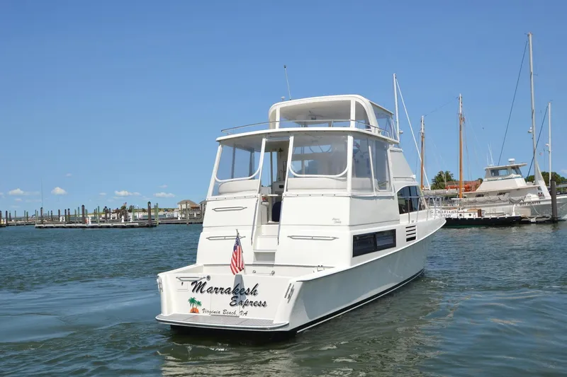 Slide: The Image of 1995 Ocean 48 Cockpit Motor Yacht docked in marina, clear sky, calm water. - 6