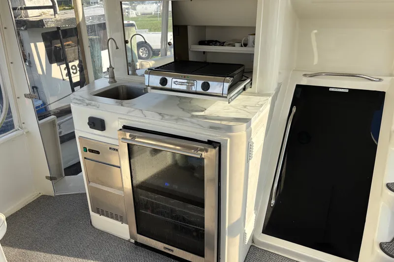 Slide: The Image of Compact kitchen area in a 1995 Ocean 48 Cockpit Motor Yacht with sink and grill. - 40