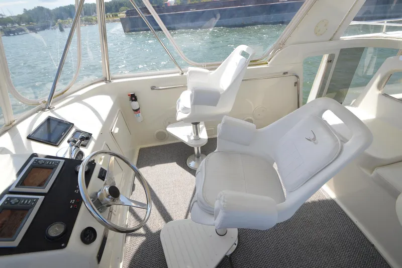 Slide: The Image of Cockpit of 1995 Ocean 48 Cockpit Motor Yacht with steering wheel and white captain chairs. - 76