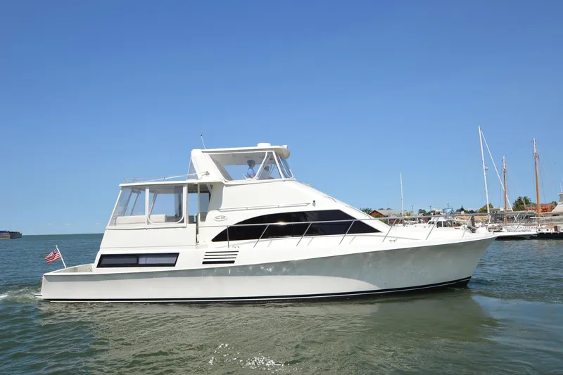Slide: The Image of 1995 Ocean 48 Cockpit Motor Yacht cruising on calm waters under clear blue sky. - 7