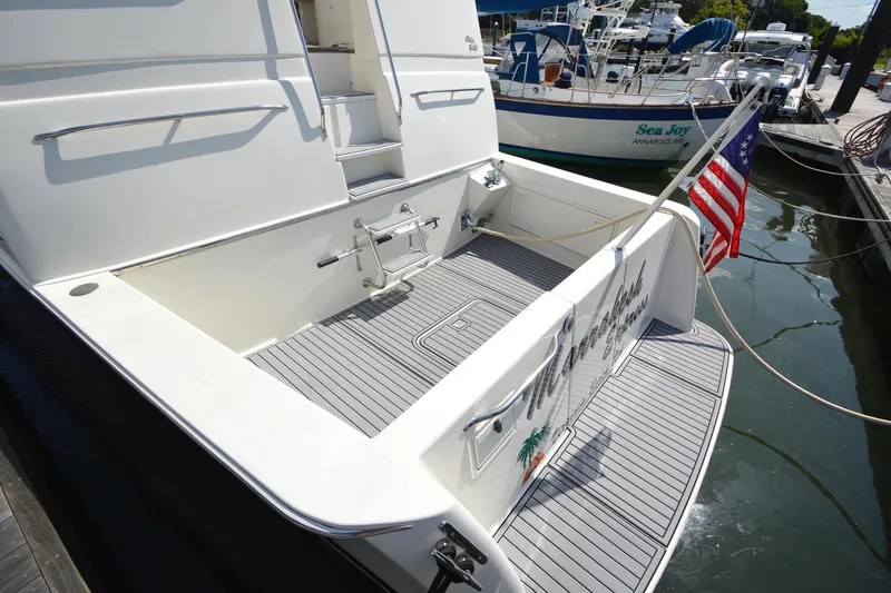 Slide: The Image of 1995 Ocean 48 Cockpit Motor Yacht with American flag at marina dock. - 61
