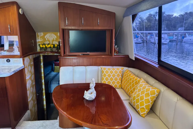 Slide: The Image of Luxurious 1995 Ocean 48 Cockpit Motor Yacht interior with elegant dining area and scenic marina view. - 9