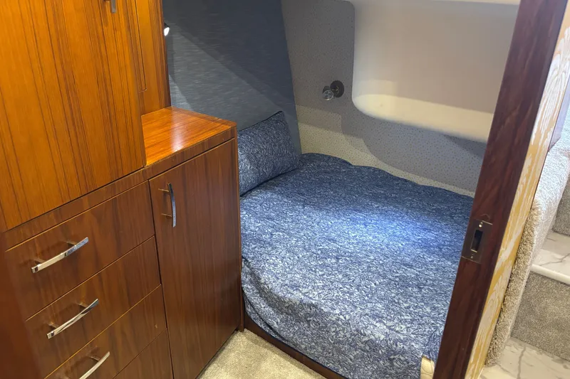 Slide: The Image of Cozy cabin interior of 1995 Ocean 48 Cockpit Motor Yacht with wooden cabinetry and blue bedding. - 32