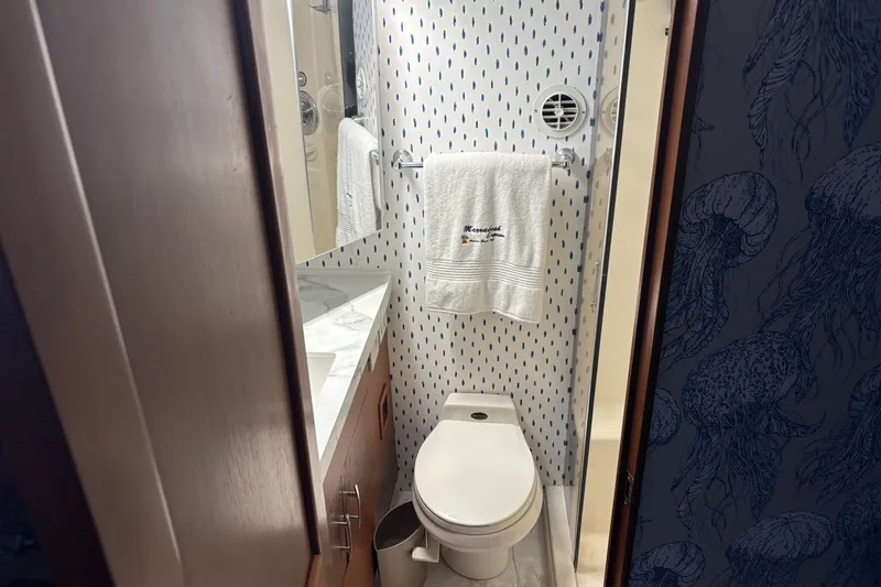 Slide: The Image of Bathroom interior of 1995 Ocean 48 Cockpit Motor Yacht with patterned wallpaper and towel. - 26
