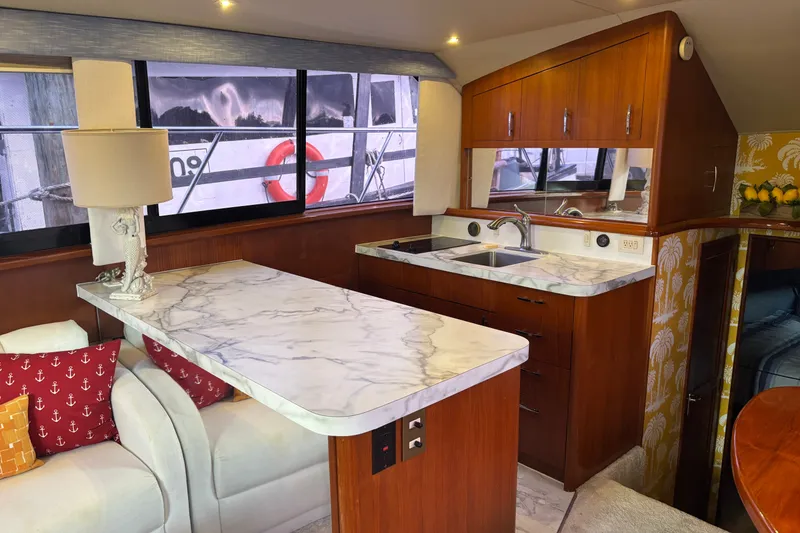 Slide: The Image of Luxurious 1995 Ocean 48 Cockpit Motor Yacht interior with marble countertops and elegant wood cabinetry. - 11