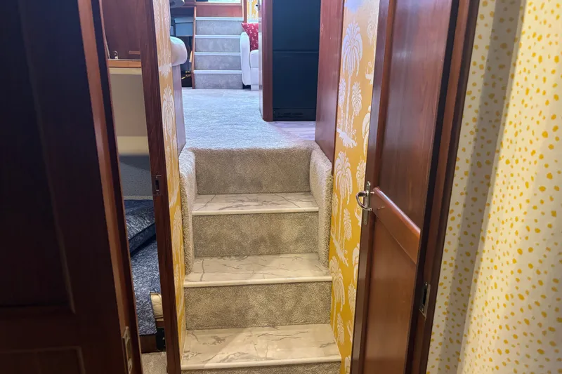 Slide: The Image of Interior view of 1995 Ocean 48 Cockpit Motor Yacht with carpeted stairs and wooden doors. - 31