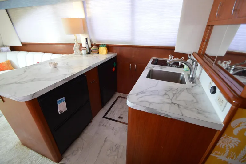 Slide: The Image of Luxurious 1995 Ocean 48 Cockpit Motor Yacht interior with marble countertops and modern amenities. - 13
