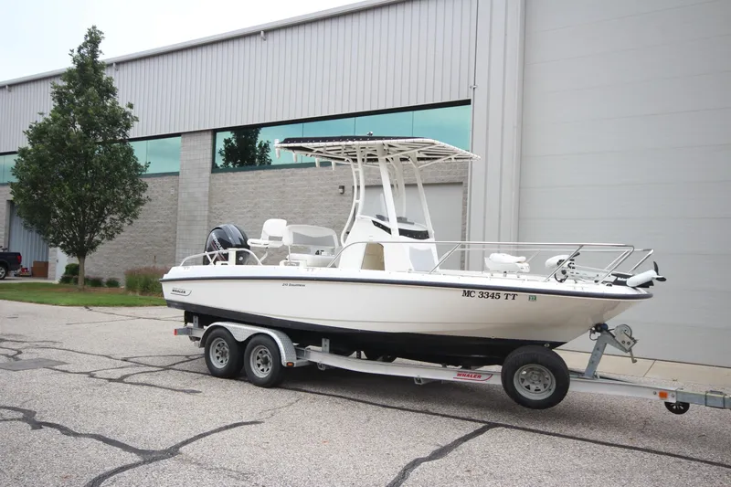 The Image of 2014 Boston Whaler 210 Dauntless boat on trailer, parked outside industrial building. - 0