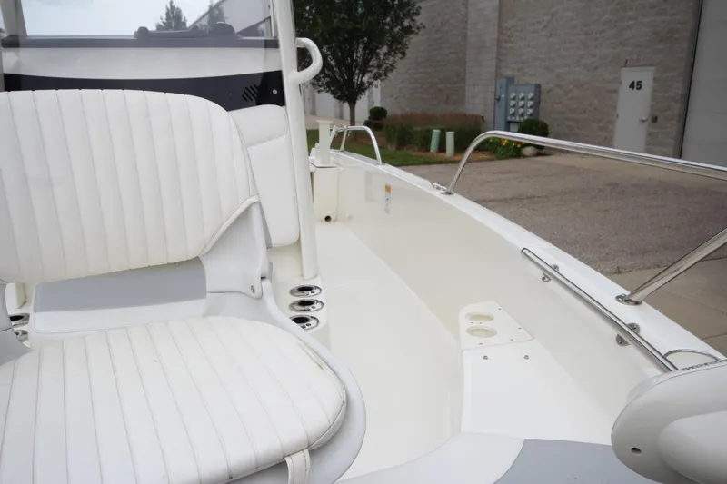 Slide: The Image of 2014 Boston Whaler 210 Dauntless boat interior with white seating and stainless steel railings. - 10