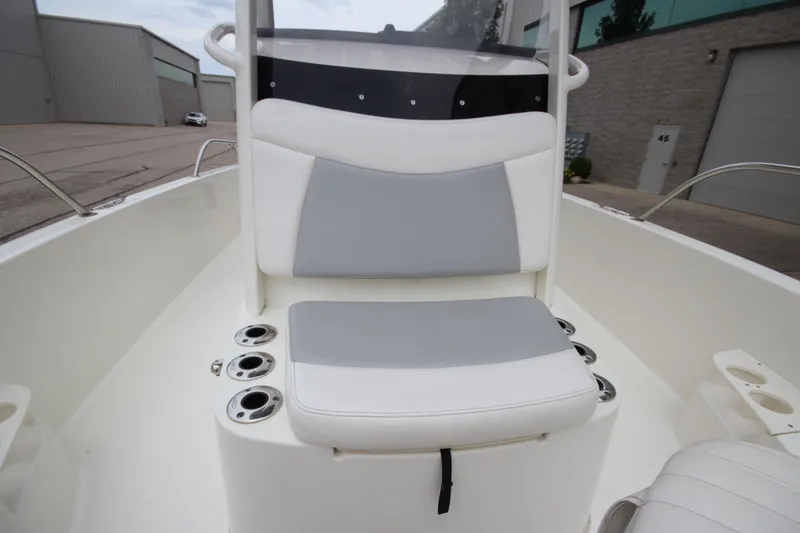 Slide: The Image of 2014 Boston Whaler 210 Dauntless boat interior with cushioned seating and cup holders. - 13