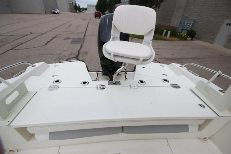 Slide: The Image of 2014 Boston Whaler 210 Dauntless boat with white seating and motor, docked outdoors. - 17