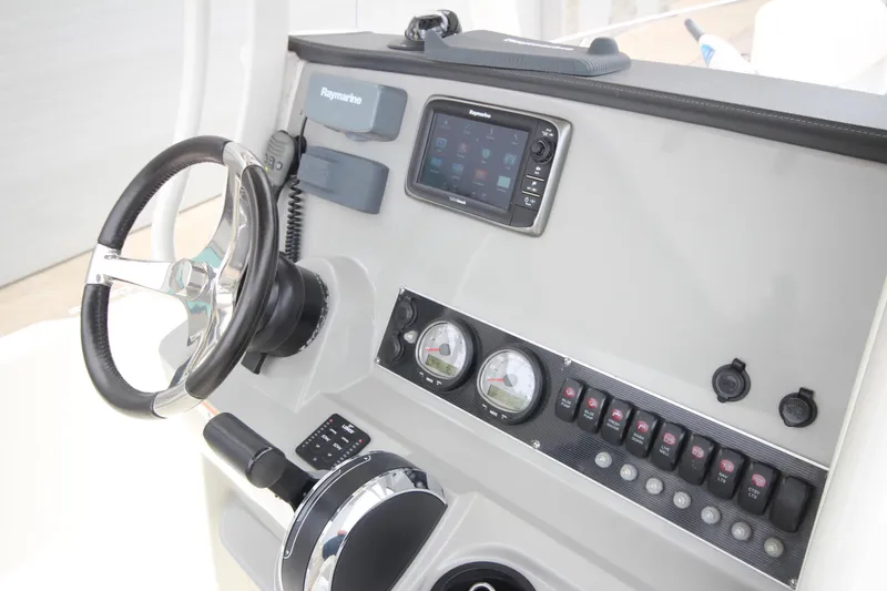 Slide: The Image of 2014 Boston Whaler 210 Dauntless dashboard with steering wheel and navigation controls. - 19