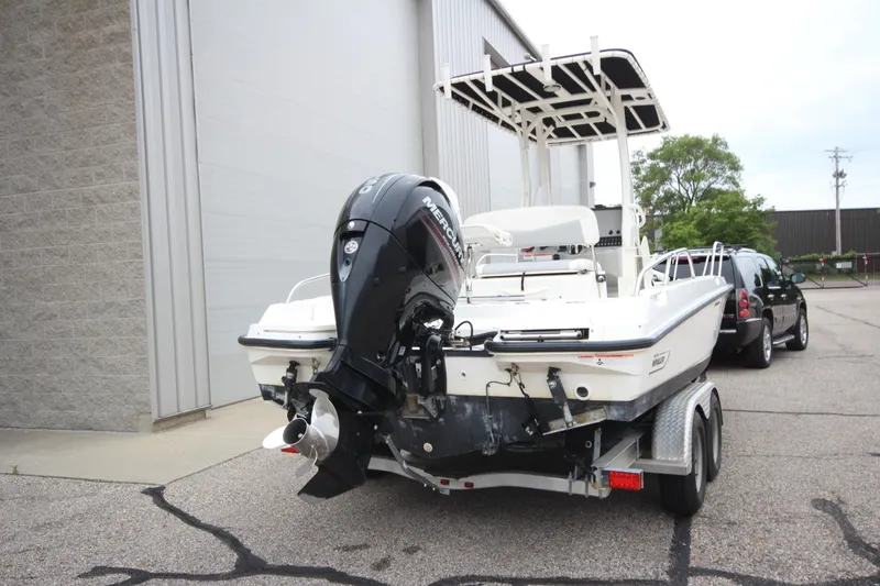 Slide: The Image of 2014 Boston Whaler 210 Dauntless boat on trailer, parked near a building. - 21