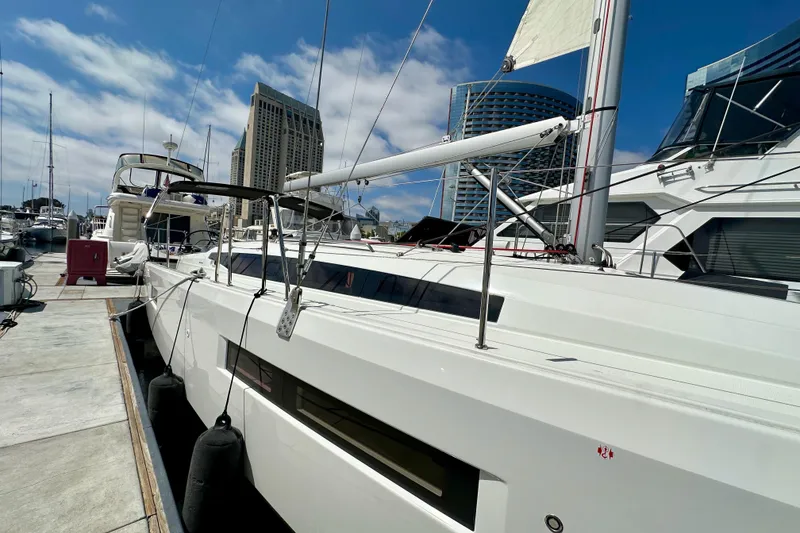 Slide: The Image of 2024 Jeanneau Sun Odyssey 410 yacht docked at marina under blue sky. - 10
