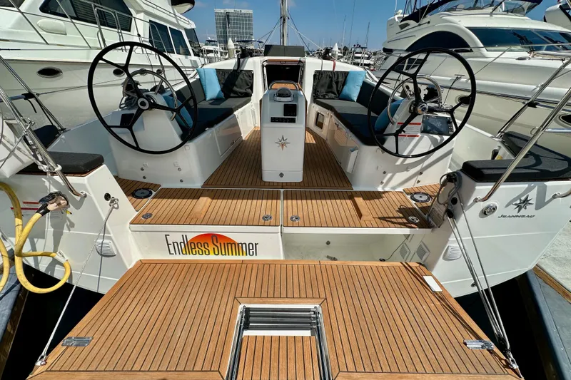 Slide: The Image of 2024 Jeanneau Sun Odyssey 410 yacht with dual steering wheels and teak deck, docked in marina. - 14