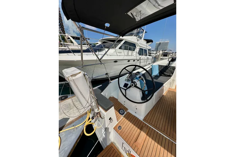 Slide: The Image of 2024 Jeanneau Sun Odyssey 410 sailboat cockpit with steering wheel, docked at marina. - 15