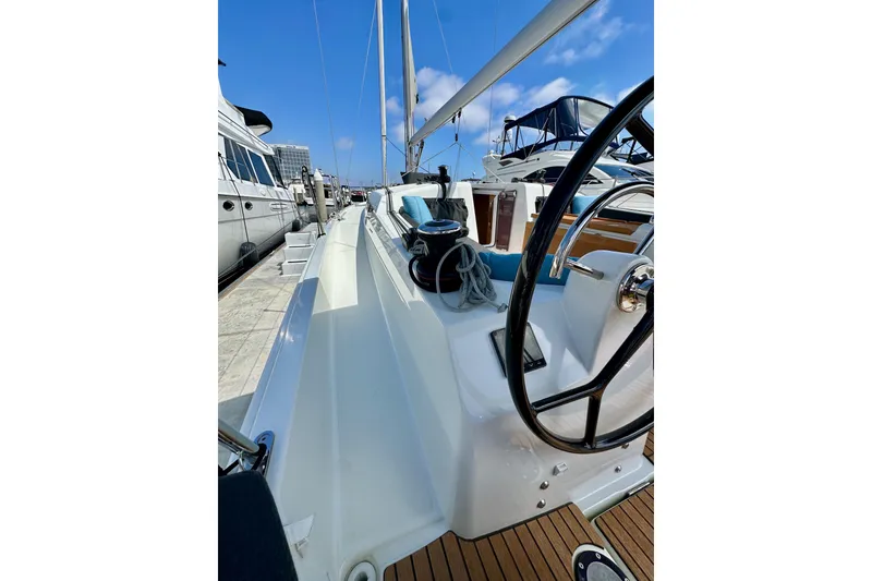 Slide: The Image of 2024 Jeanneau Sun Odyssey 410 sailboat docked, showcasing sleek deck and steering wheel. - 19