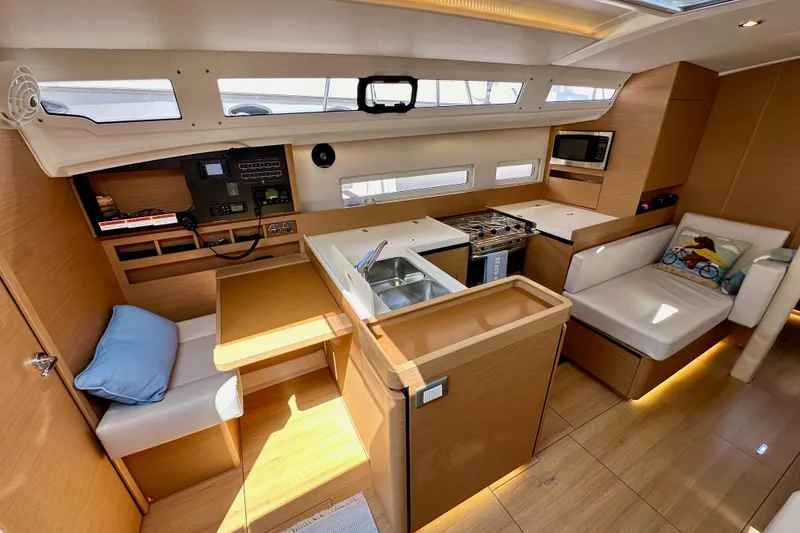Slide: The Image of 2024 Jeanneau Sun Odyssey 410 interior with modern kitchen and cozy seating area. - 48