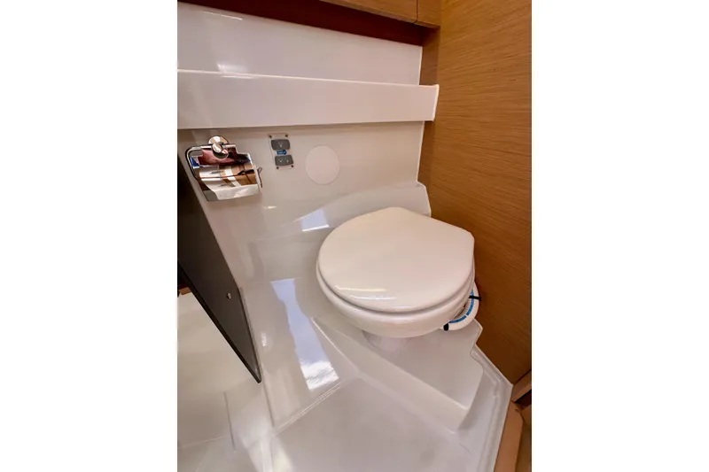 Slide: The Image of 2024 Jeanneau Sun Odyssey 410 yacht bathroom with modern toilet and wooden accents. - 68