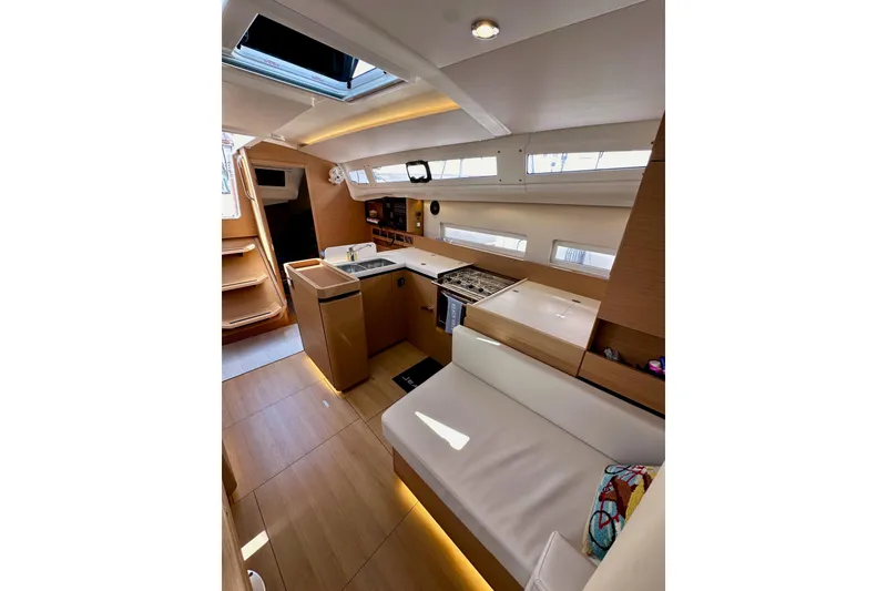 Slide: The Image of Interior of 2024 Jeanneau Sun Odyssey 410 yacht, featuring modern kitchen and seating area. - 73