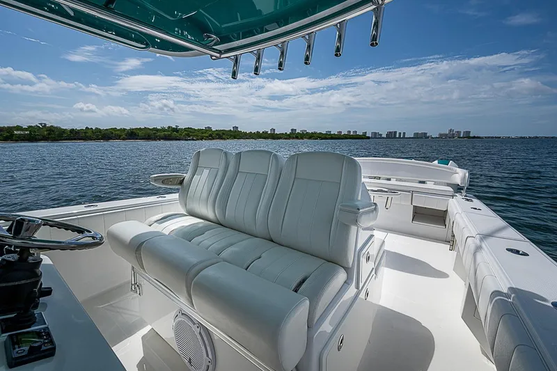 Slide: The Image of 2020 Bahama 41 boat interior with white seating, overlooking calm waters and distant skyline. - 12